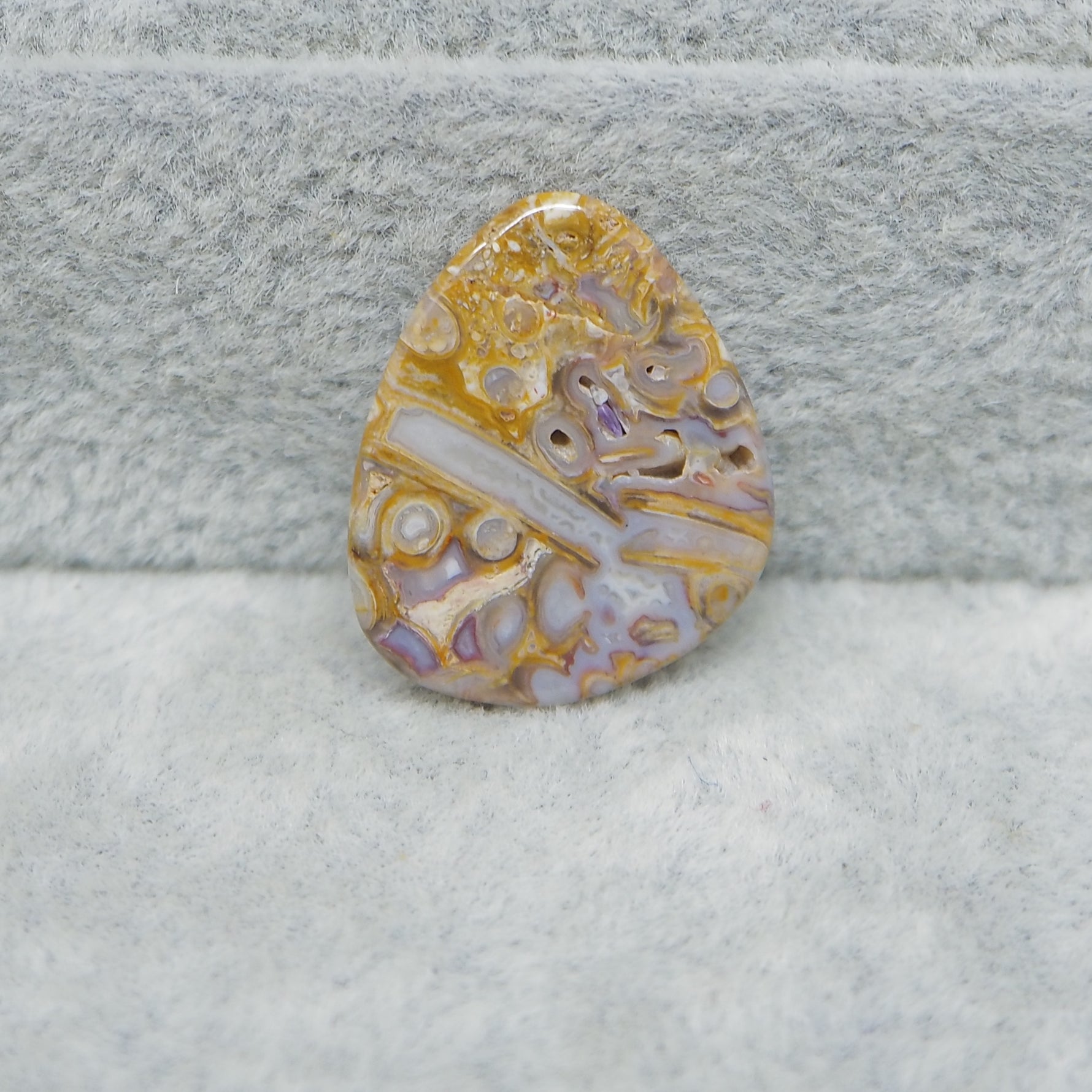 Decorative stone with intricate patterns on a textured gray surface