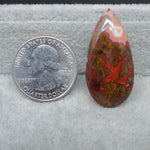 Marbled stone next to a U.S. quarter dollar on a textured gray surface