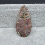 Polished stone with a textured surface on a gray background