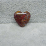 Heart-shaped amber stone on a textured gray surface