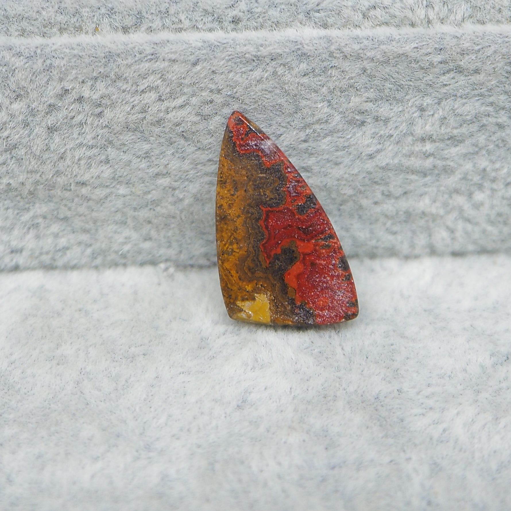 Multicolored stone on a textured gray surface