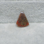 Triangular stone with red and brown colors on a gray surface