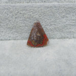 Rusty traffic cone on a snowy ground with a concrete wall in the background
