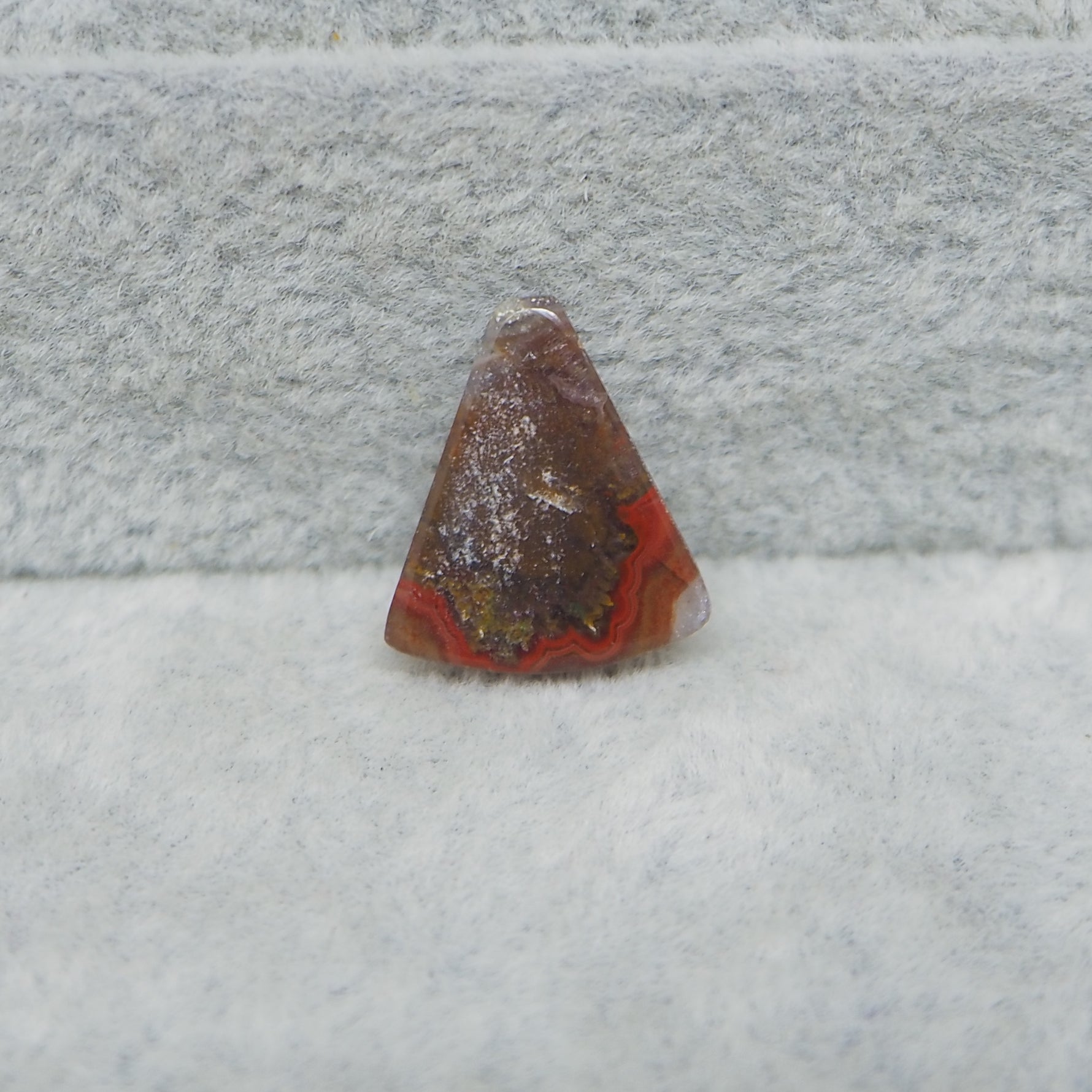 Rusty traffic cone on a snowy ground with a concrete wall in the background