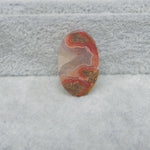 Oval-shaped multicolored stone on a textured gray surface