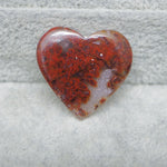 Heart-shaped red and white stone on a textured gray background