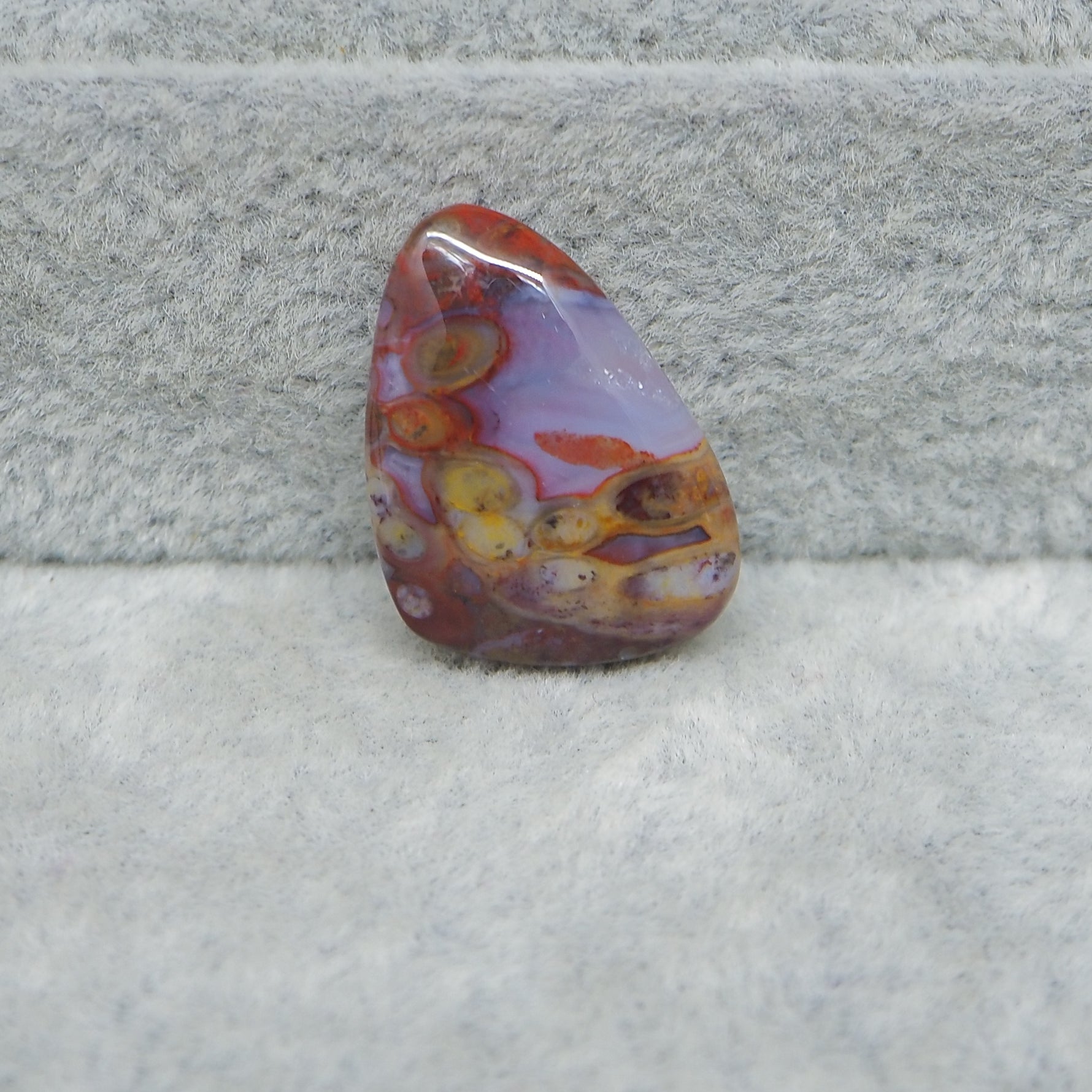 Multicolored stone on a textured gray surface