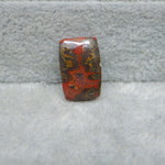 Rectangular red and brown stone on a gray surface