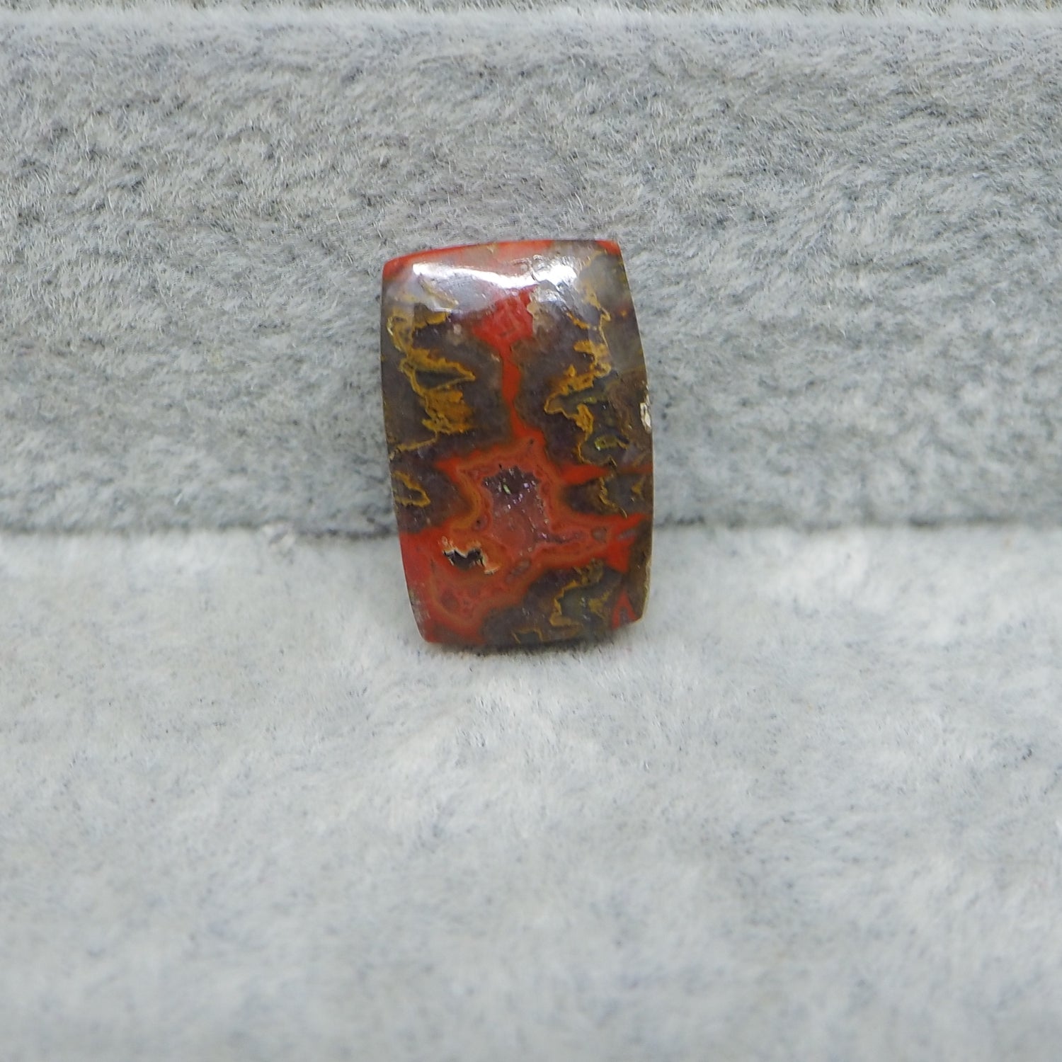 Rectangular red and brown stone on a gray surface