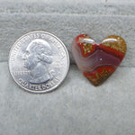 Heart-shaped agate stone next to a U.S. quarter dollar on a gray surface