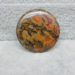 Round, multicolored stone on a textured gray background