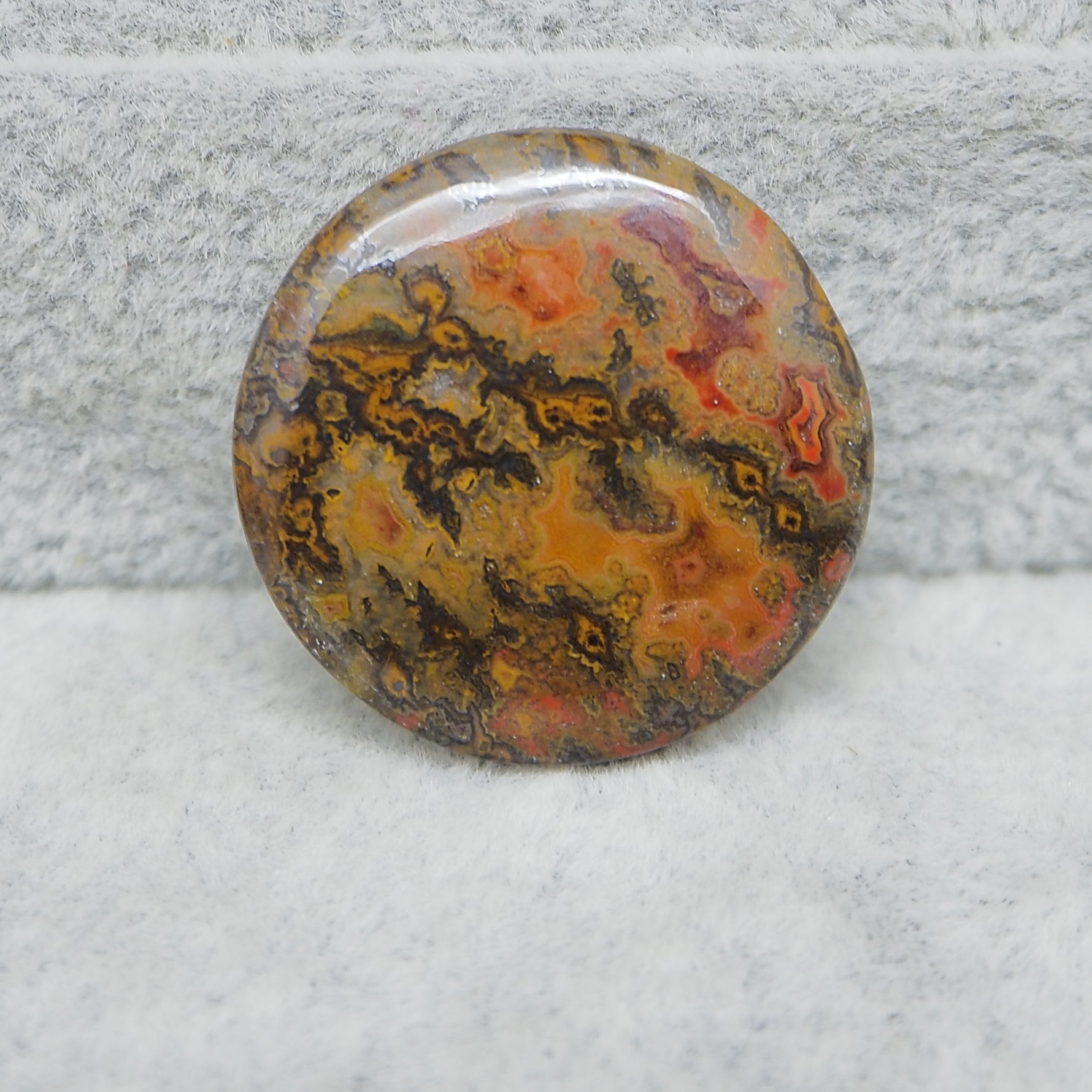 Round, multicolored stone on a textured gray background