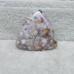 Polished piece of agate with a multicolored pattern on a textured surface