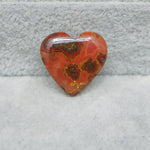 Heart-shaped red and brown stone on a gray surface
