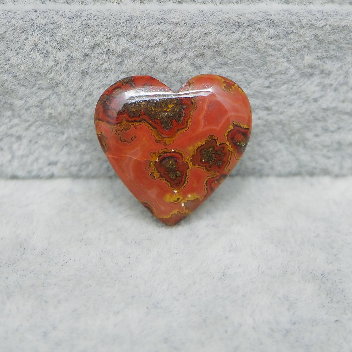 Heart-shaped red and brown stone on a gray surface