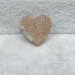 Heart-shaped stone on a textured surface
