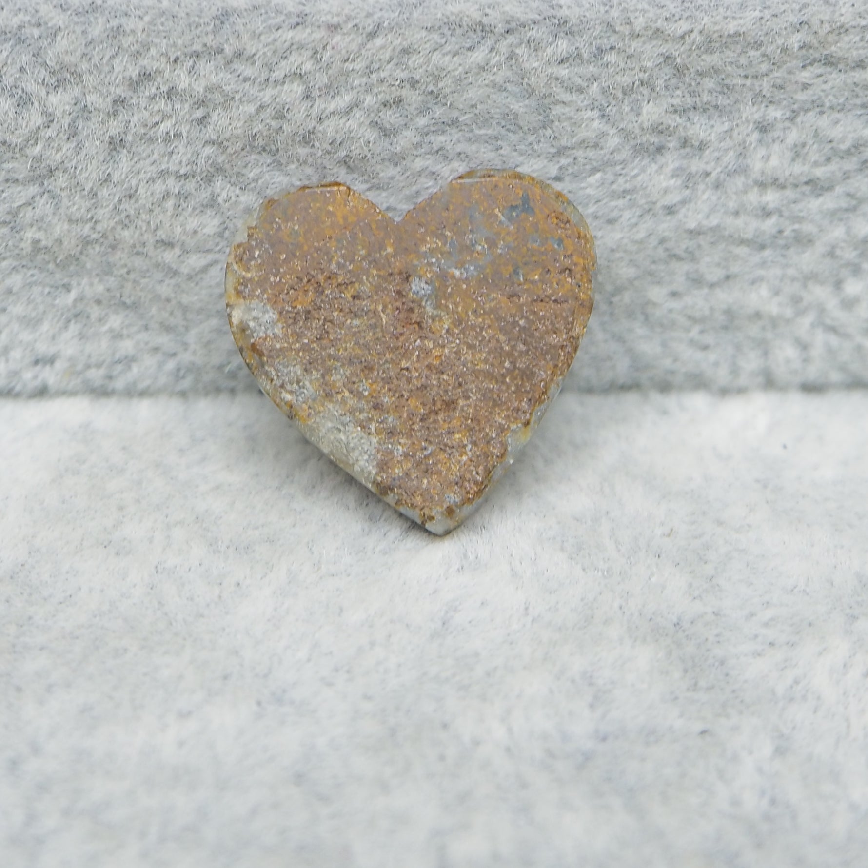 Heart-shaped stone on a textured surface