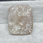 Square stone with a textured surface on a snowy background
