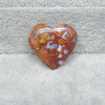 Heart-shaped amber stone on a gray fabric background