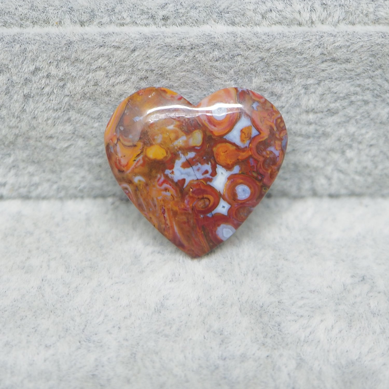 Heart-shaped amber stone on a gray fabric background