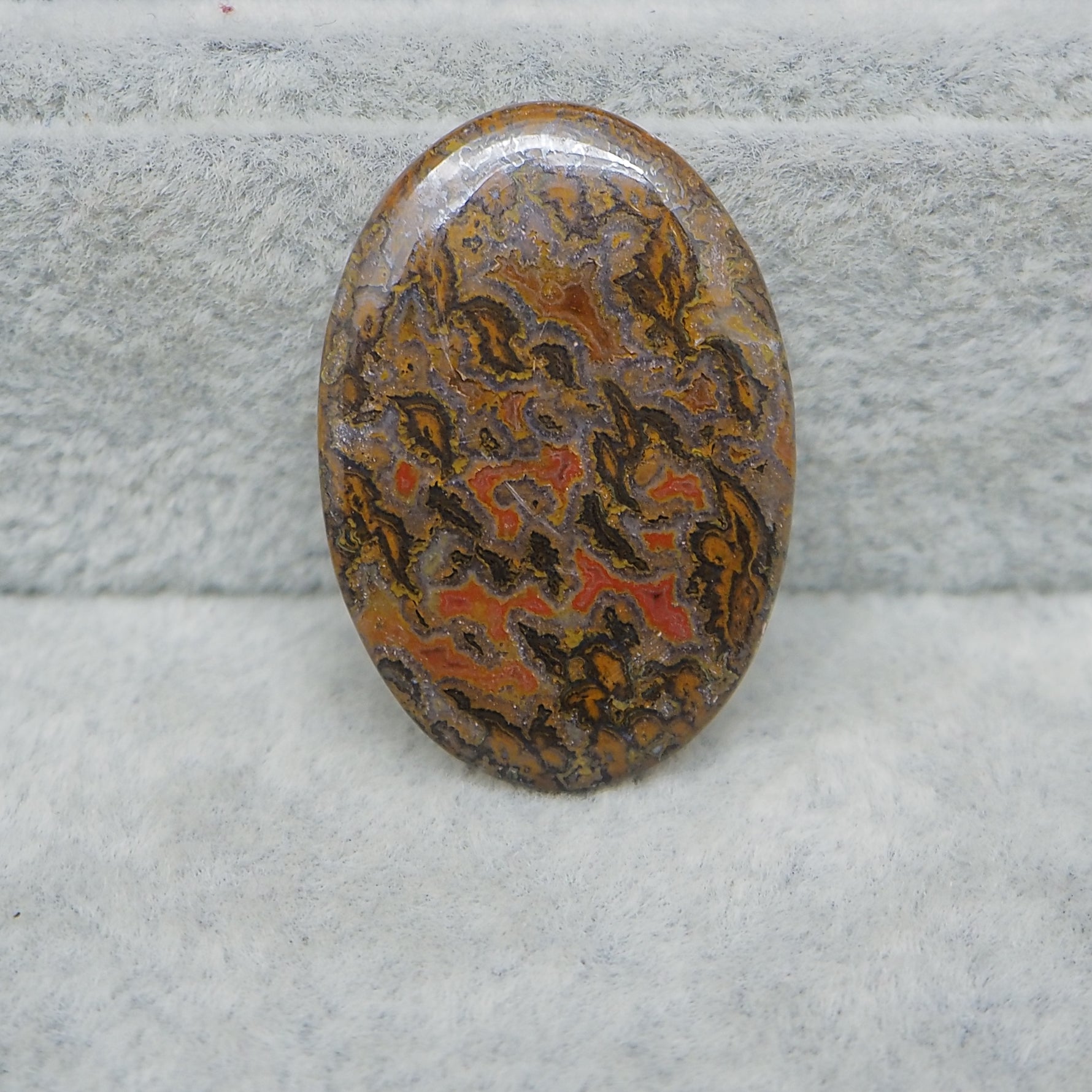 Decorative stone with intricate patterns on a textured gray background