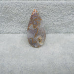 Teardrop-shaped agate stone on a textured gray background