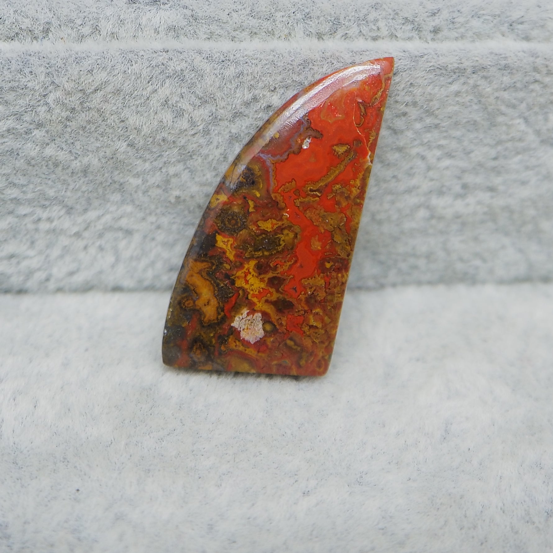 Marbled red, orange, and brown stone on a gray surface