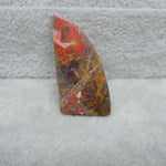 Decorative stone with multicolored patterns on a textured gray surface