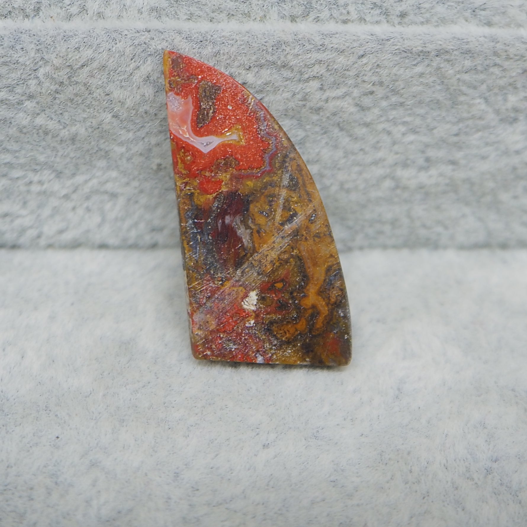 Decorative stone with multicolored patterns on a textured gray surface