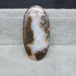 Oval-shaped agate stone on a gray surface