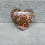 Heart-shaped agate stone on a textured gray background