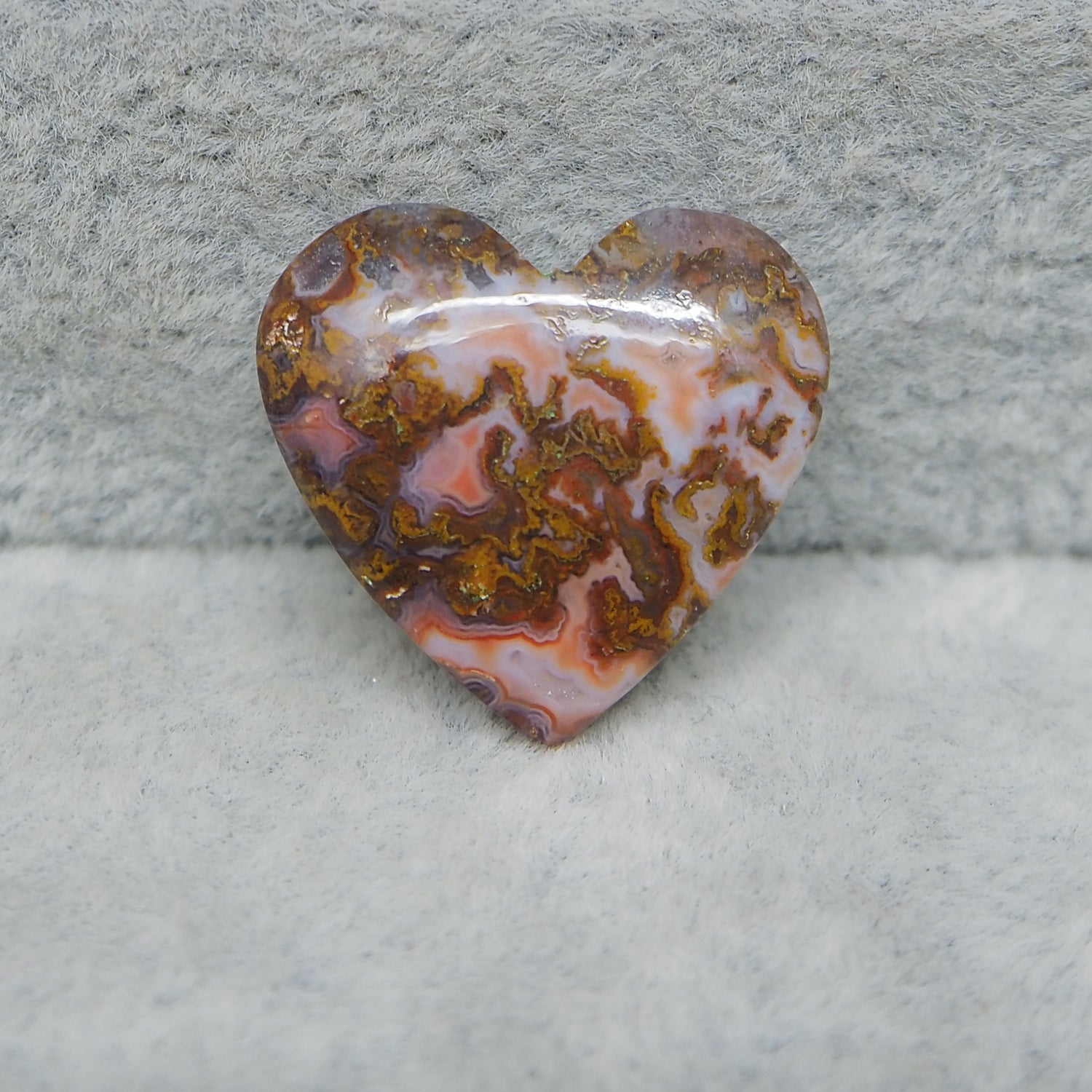 Heart-shaped agate stone on a textured gray background