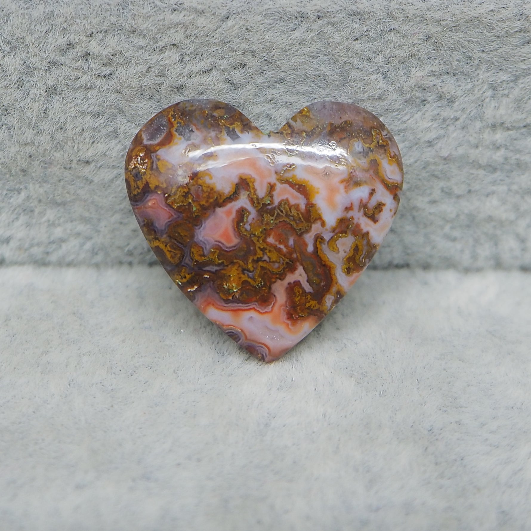 Heart-shaped agate stone on a textured gray background
