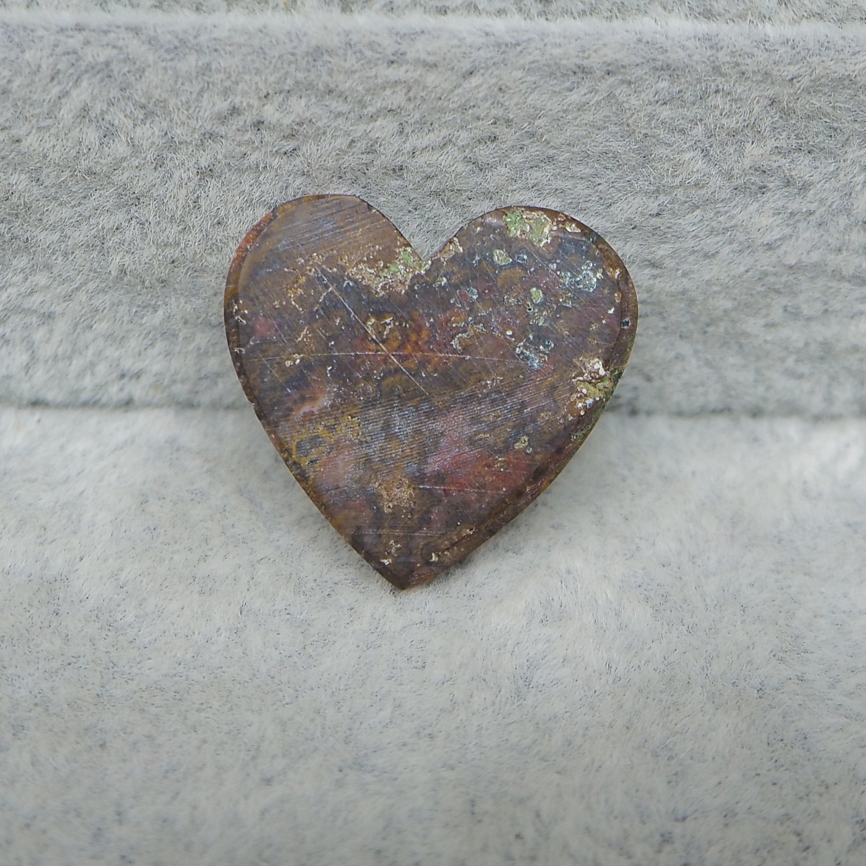 Rust-colored heart-shaped object on a gray surface