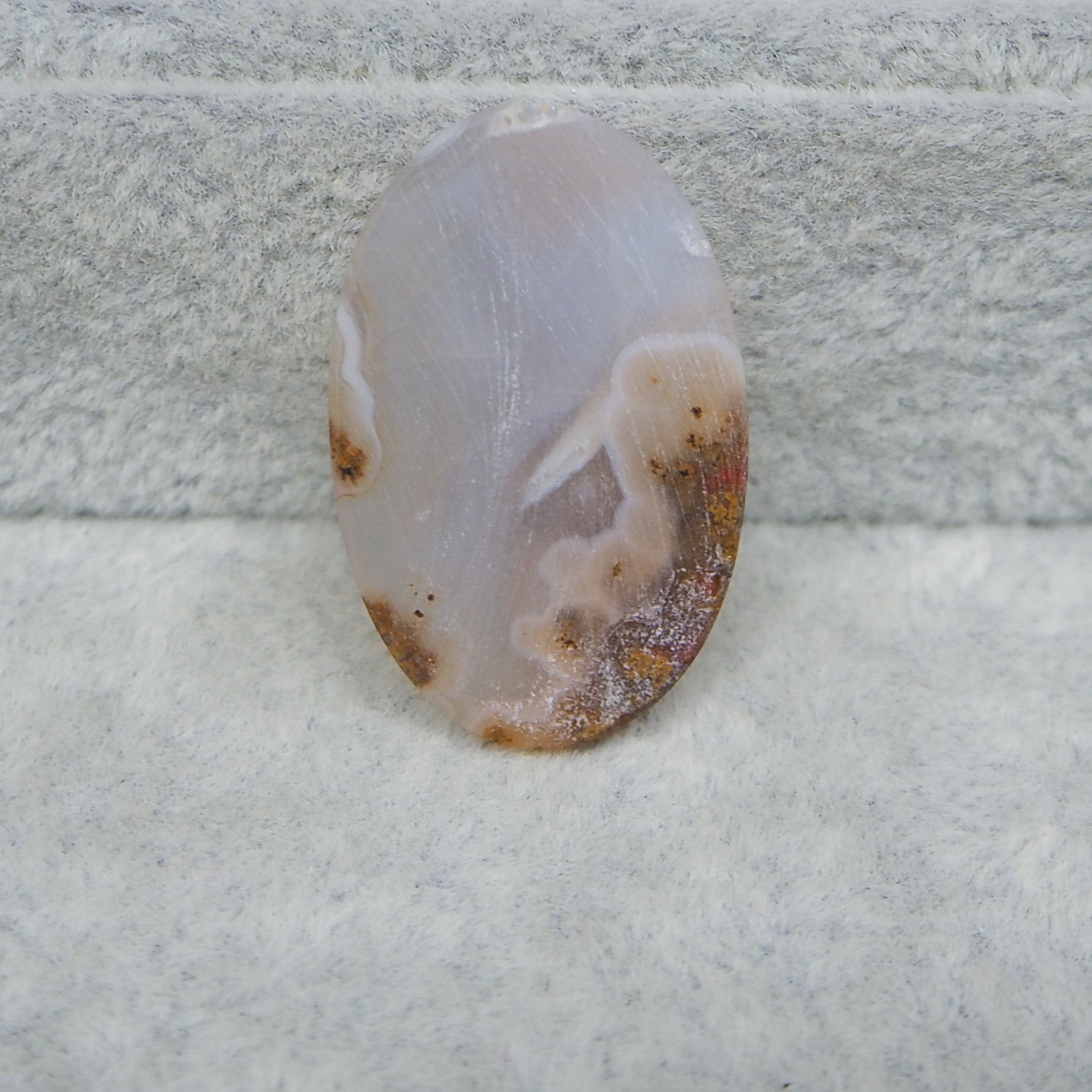 Polished agate stone on a textured white surface