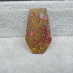 Decorative stone with red and yellow patterns on a textured gray background