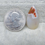 Glass teardrop pendant next to a U.S. quarter dollar coin on a textured surface