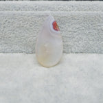 Teardrop-shaped crystal on a textured surface