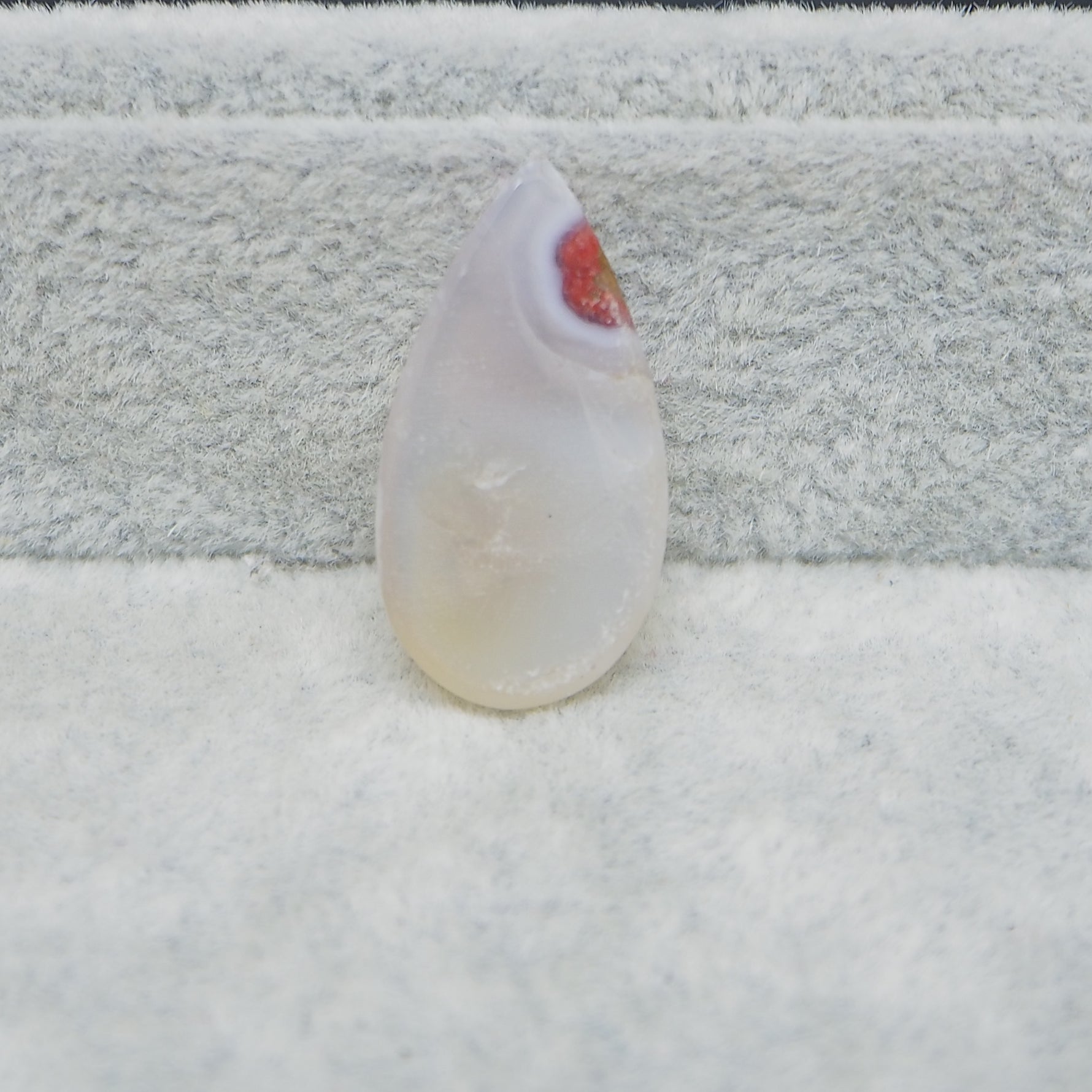 Teardrop-shaped crystal on a textured surface