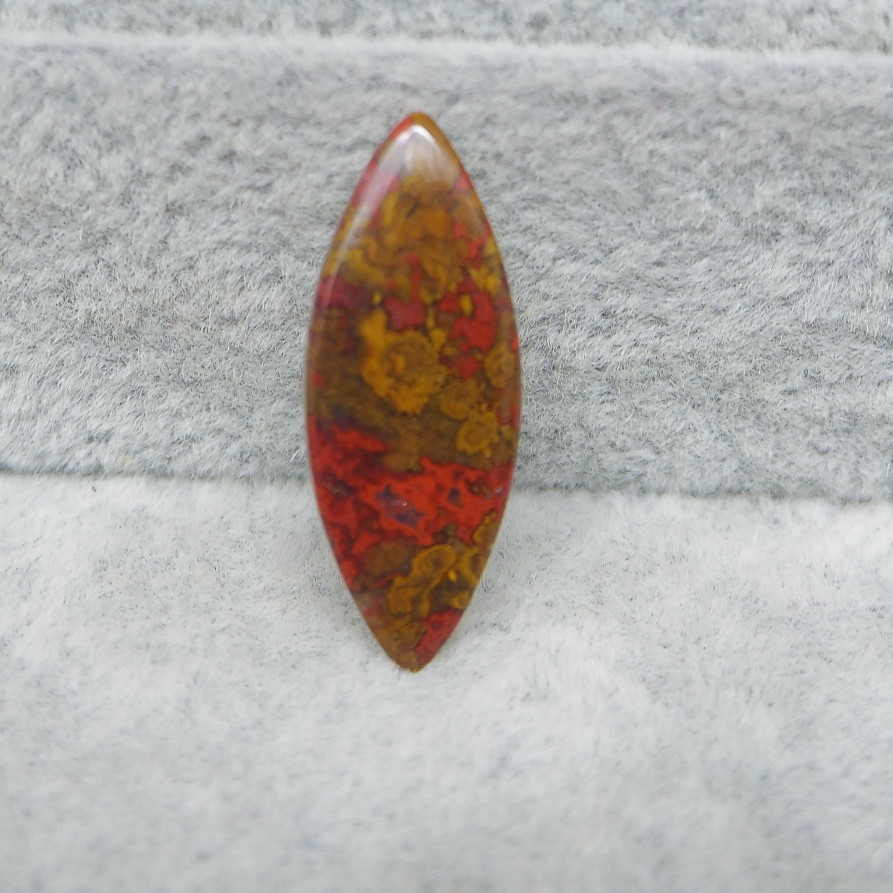 Multicolored stone on a textured gray background