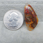 Marbled stone next to a U.S. quarter dollar coin on a gray surface