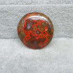 Polished red and brown stone on a gray surface