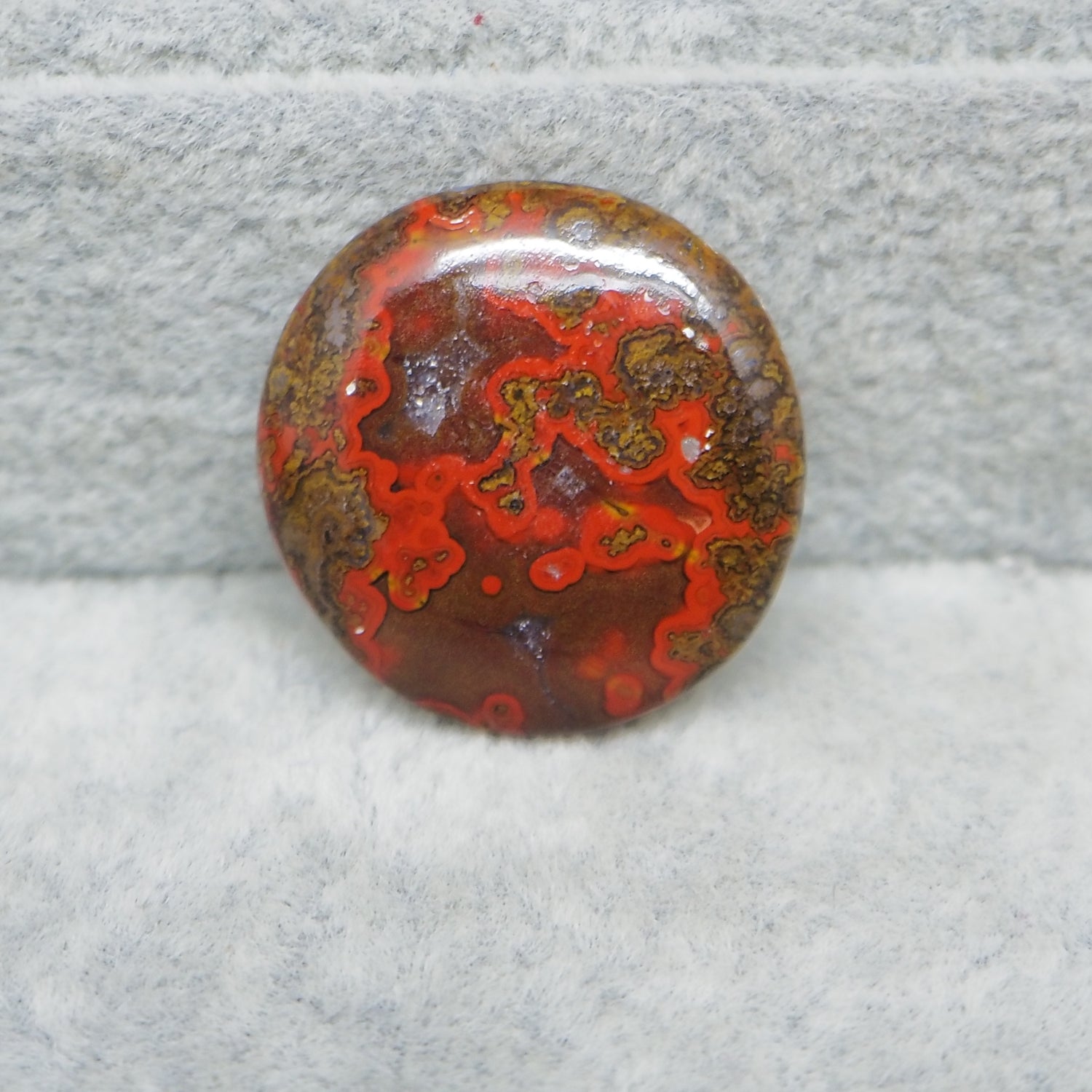 Polished red and brown stone on a gray surface