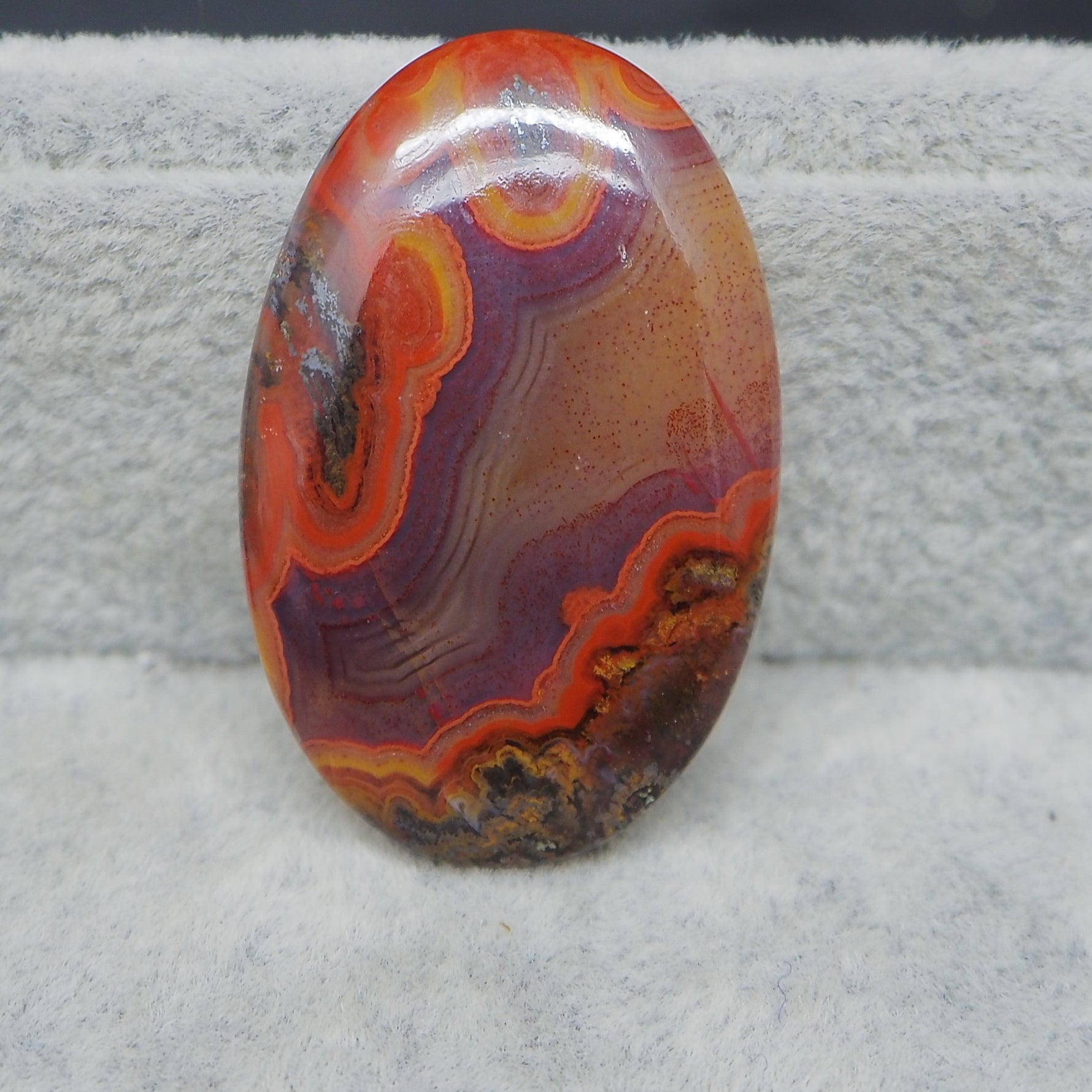 Oval-shaped colorful stone on a textured gray background