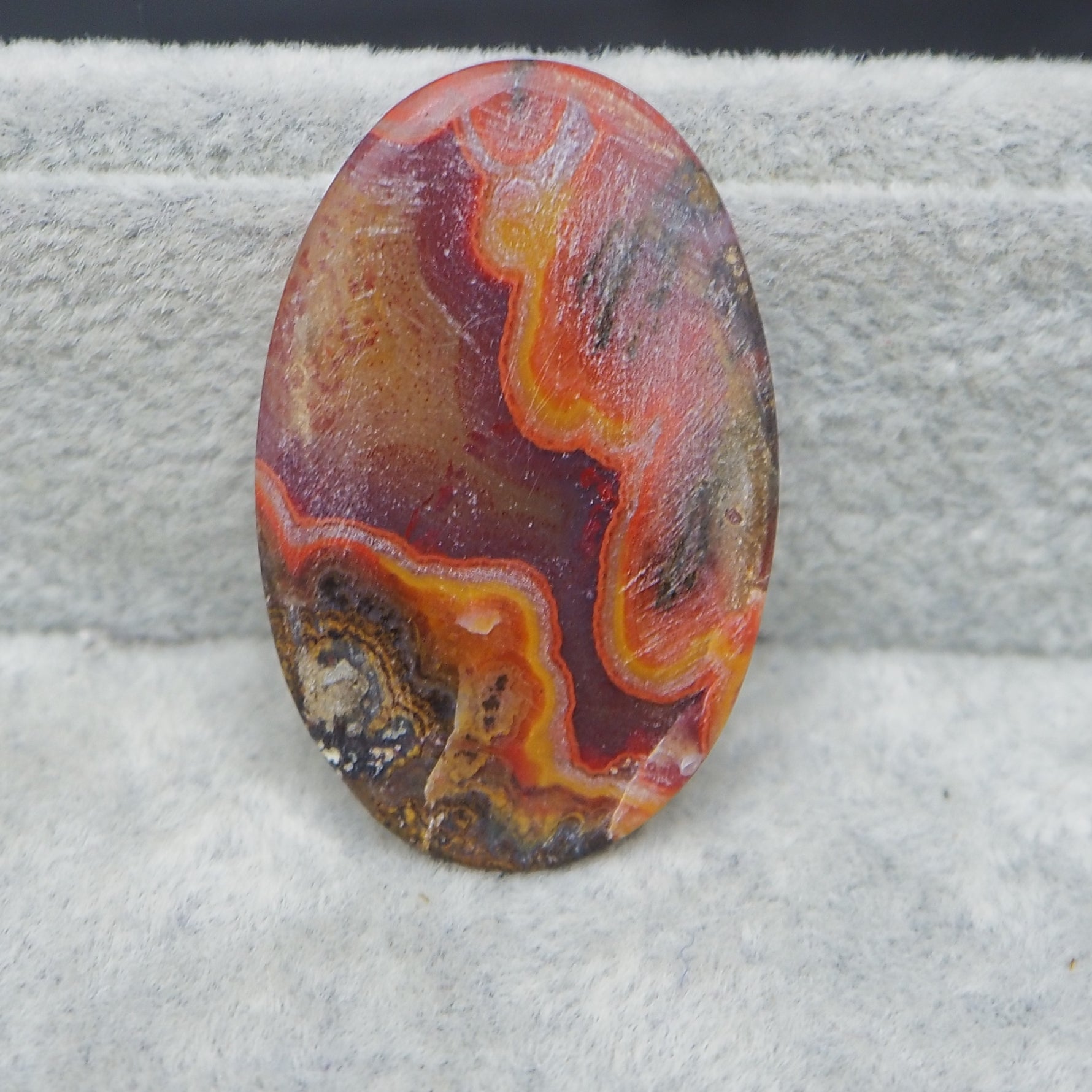 Multicolored oval stone on a textured gray surface