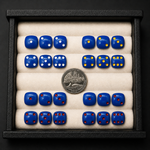 Set of blue dice with different numbers of dots, displayed with a coin for scale.