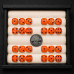 Set of orange dice with black dots in a display case, accompanied by a silver coin.