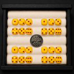 Set of yellow dice with red dots arranged in a display case, showing a quarter coin for scale.