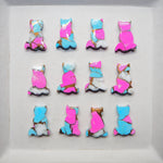 Colorful cat-shaped cookies on a white surface
