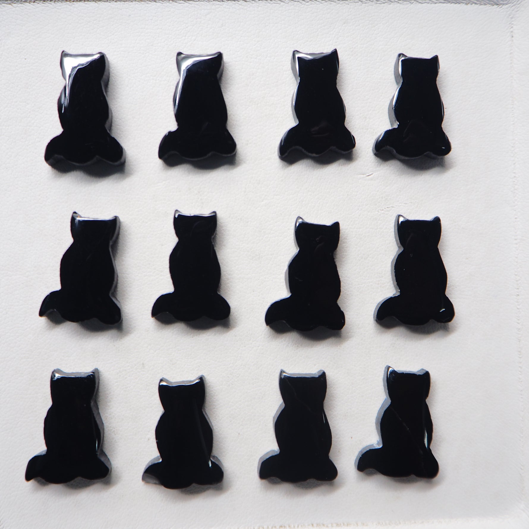 Black cat-shaped objects arranged in a grid on a white background